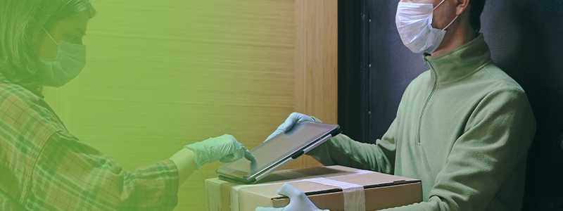 Deliveryman and customer wearing masks while the customer provides an electronic signature